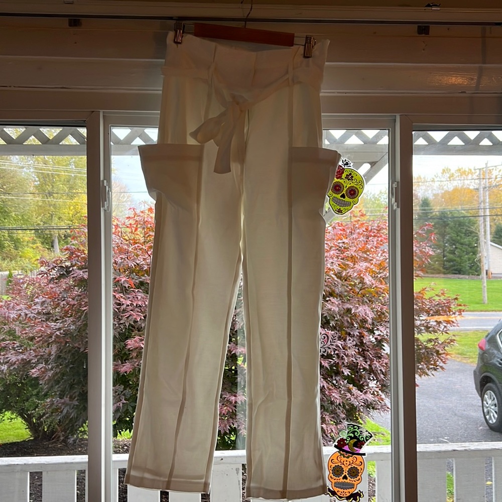 White pants, paper bag top with tie and clip and zipper. Size large